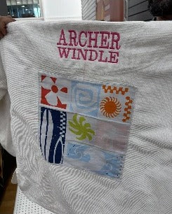 ARCHER WINDLE in pink thread above a colourful artwork panel on a white gi back