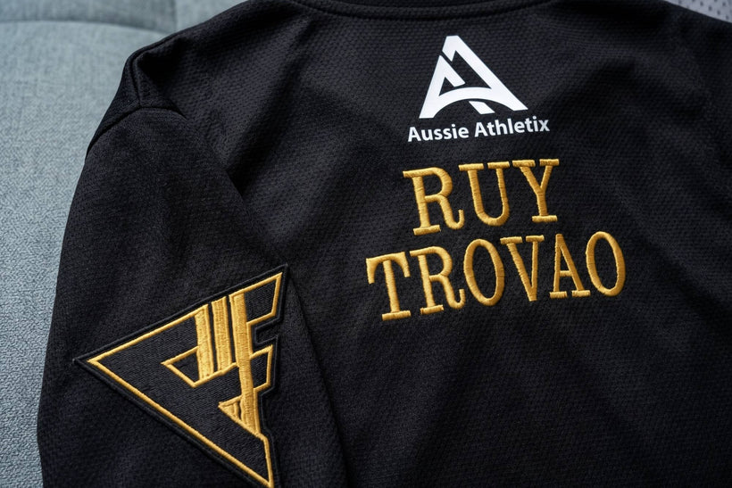 Gold embroidered name on the back of a black gi, stitched in-house