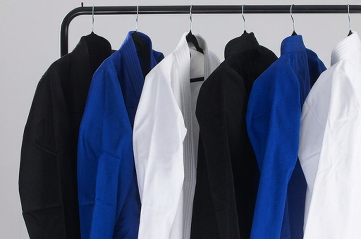 Black, blue and white gis hanging on a rack